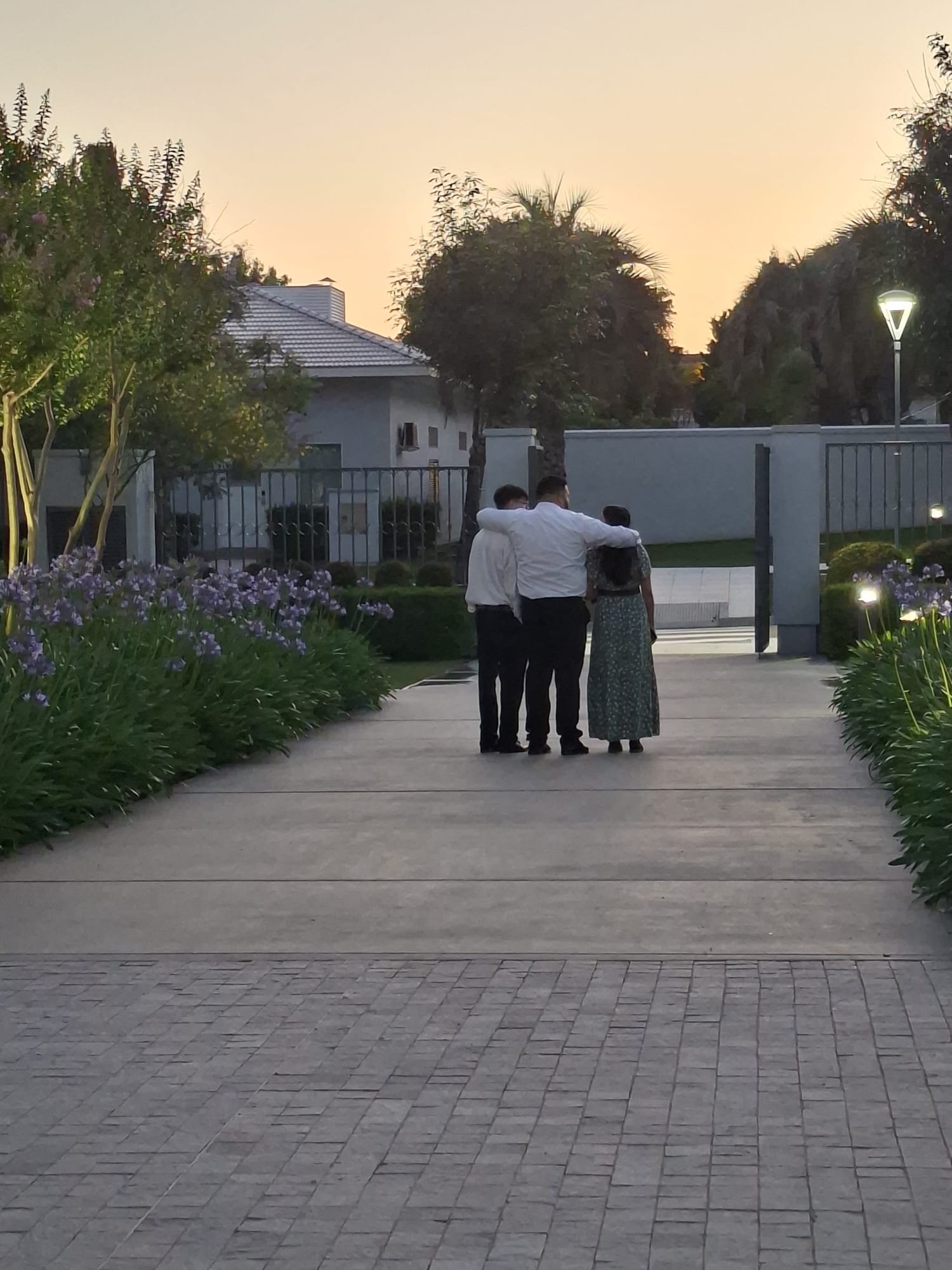 Two people sharing a warm hug in the beautifully manicured temple gardens